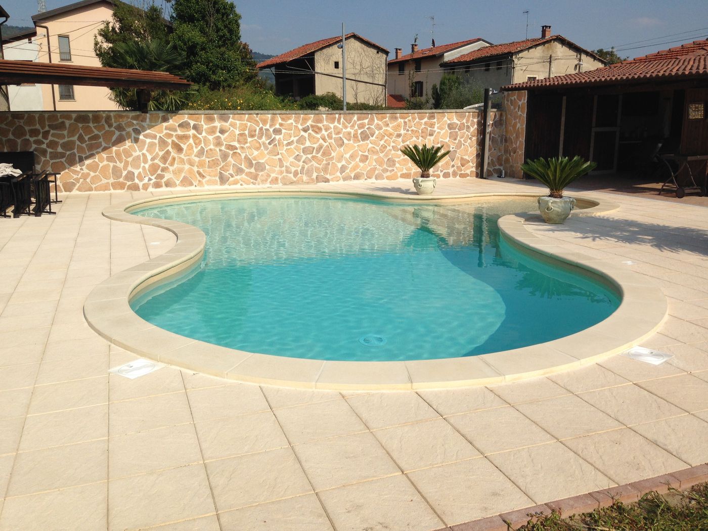Piscina a forma libera con bordi chiari